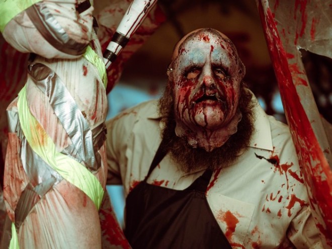 Bloodied, masked figure in a horror-themed setting.