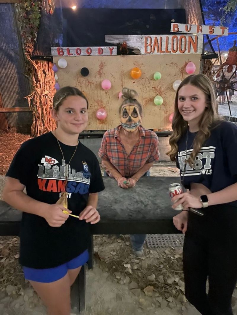 Two guests and a character at the Bloody Balloon Burst target booth
