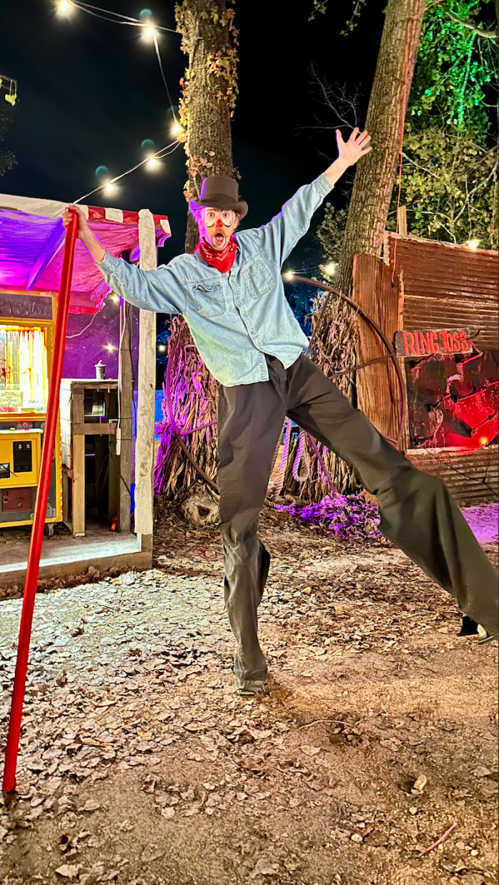 Stilt performer towering over the games at Exiled’s Twisted Carnival