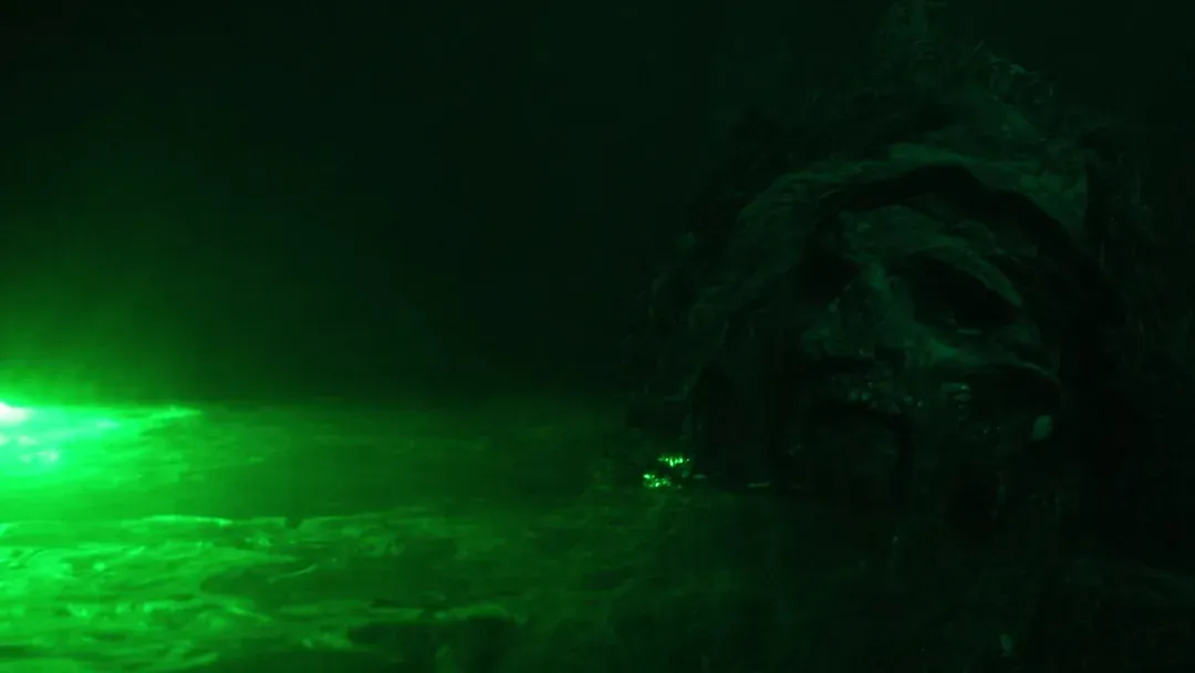 A swamp creature rises through green laser-lit fog in the Exiled preview video
